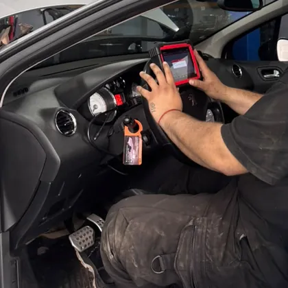 Técnico de PENTAGOM usando un escáner automotor conectado a un auto