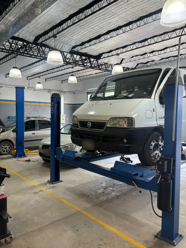 Utilitario sobre el elevador de cuatro columnas en el taller de PENTAGOM